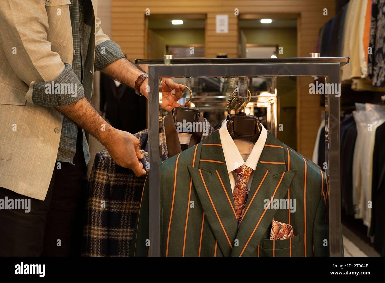 L'acquirente sta controllando le giacche in un negozio di abbigliamento su misura Foto Stock