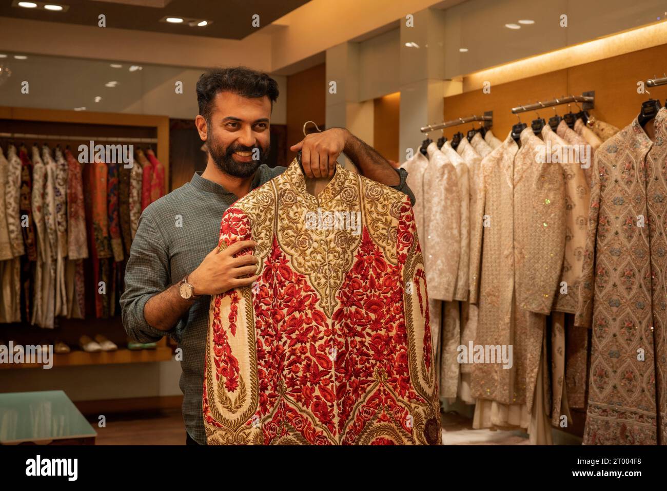 Compratore che prova l'abbigliamento indiano in un negozio di abbigliamento Foto Stock