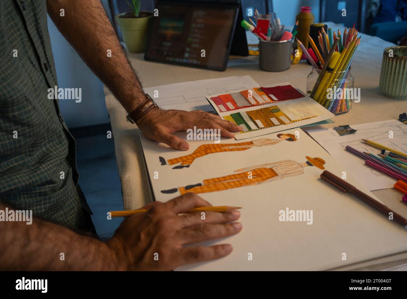 Uno stilista di moda che lavora sugli schizzi per la sua prossima collezione Foto Stock