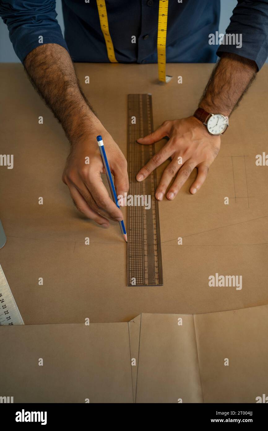 Un designer maschile che crea motivi per una collezione di abbigliamento maschile nel suo studio Foto Stock