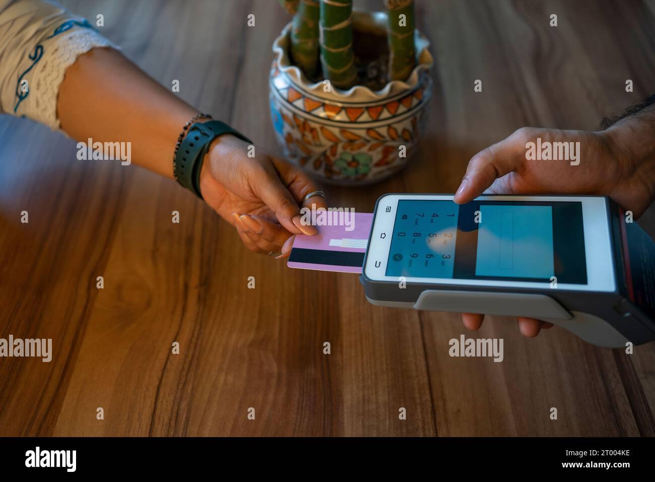 Un acquirente che effettua un pagamento tramite una macchina per carte di credito Foto Stock