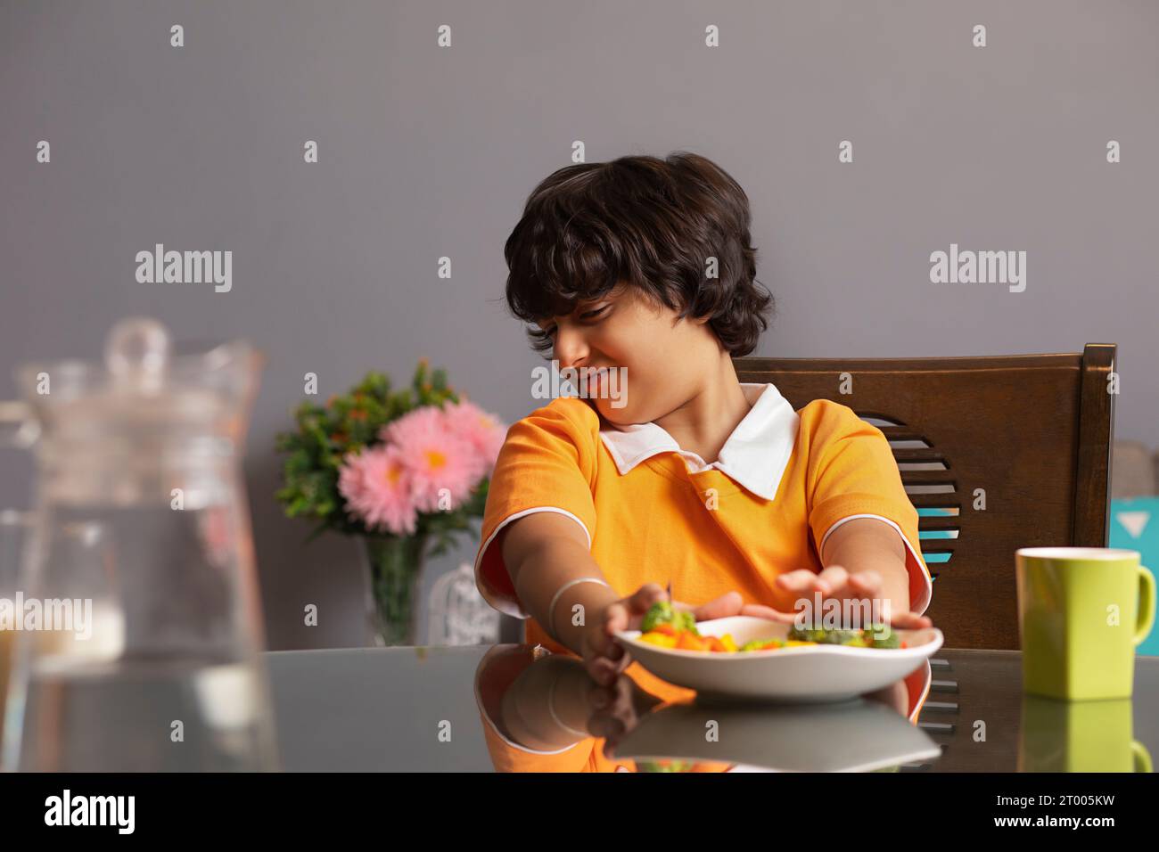Ritratto di un ragazzo infelice che mangia broccoli Foto Stock