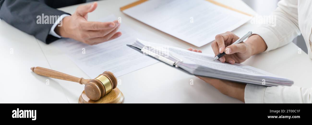 Il consulente legale presenta al client un contratto firmato con il martello e il diritto legale. Giustizia e avvocato concetto Foto Stock