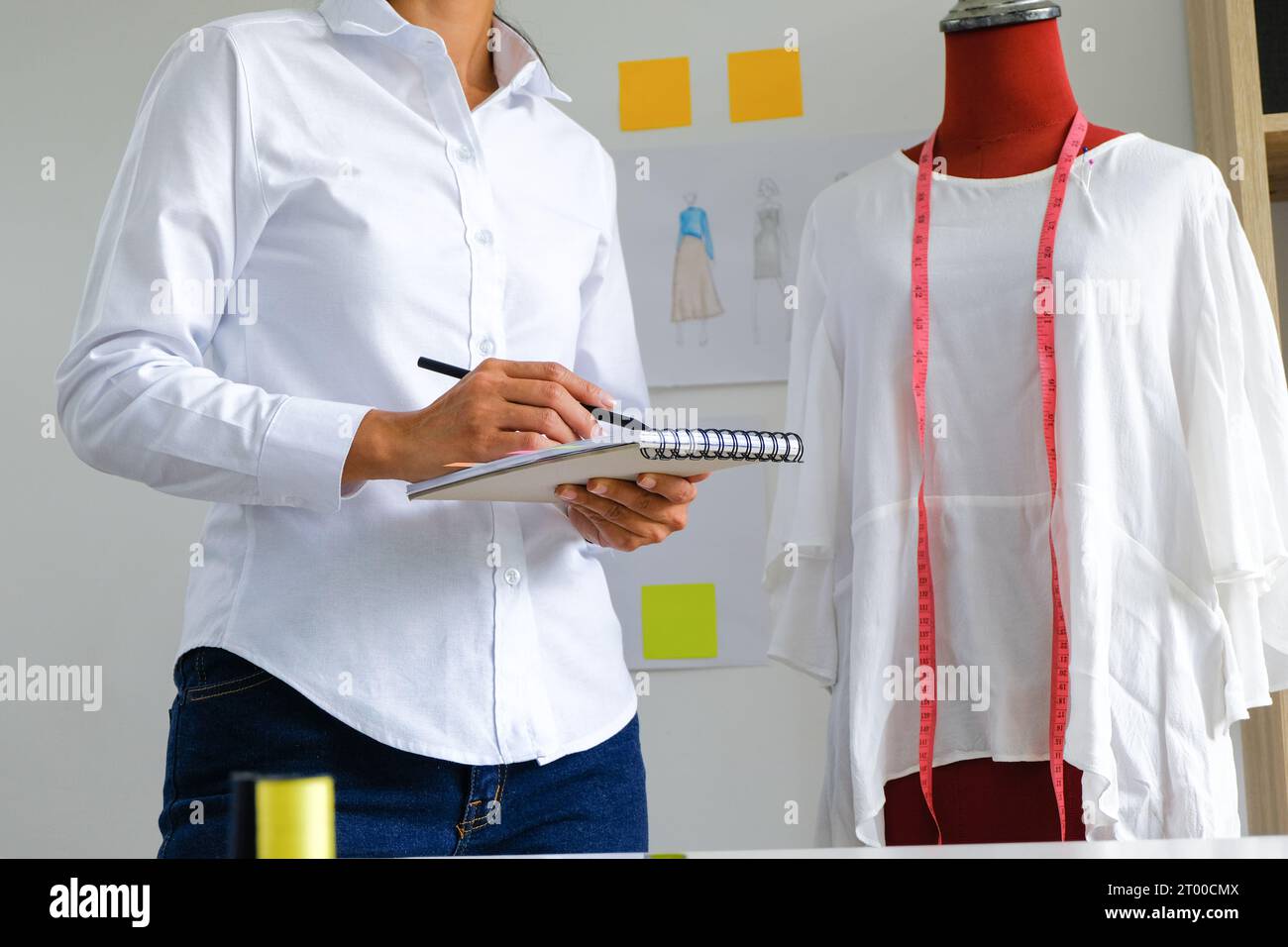 Donna sartoriale che lavora in sartoria elegante stilista sartoriale in studio di officina che disegna la nuova collezione Dressmaking e. Foto Stock