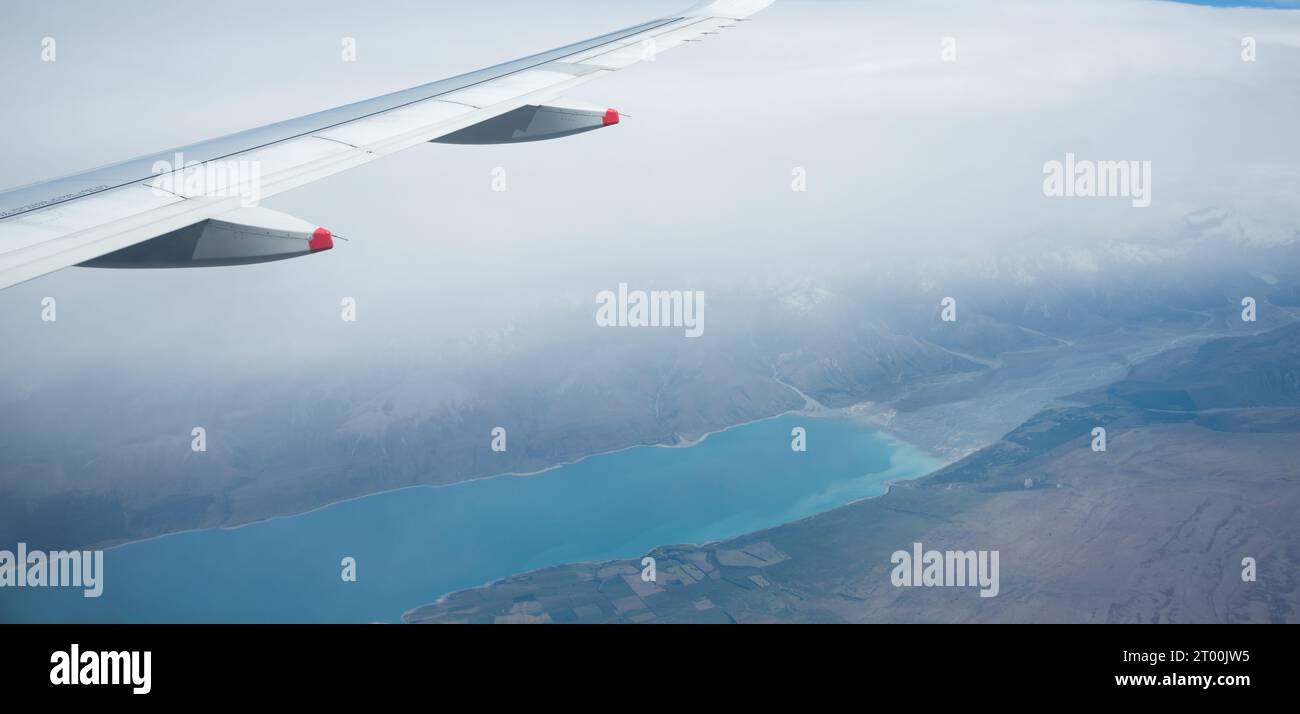 Vista aerea del lago Pukaki nella nebbia fitta, da un aereo che vola da Auckland a Queenstown. South Island. Nuova Zelanda. Foto Stock
