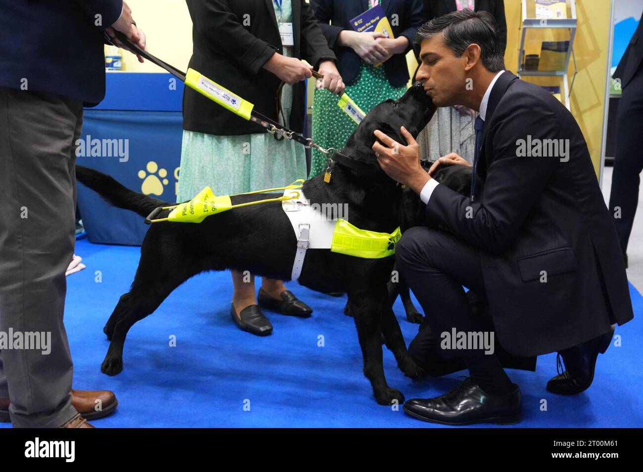 Il primo Ministro Rishi Sunak saluta un cane guida mentre visita la sala degli Espositori, nel complesso congressuale centrale di Manchester, durante la conferenza annuale del Partito Conservatore. Data immagine: Martedì 3 ottobre 2023. Foto Stock