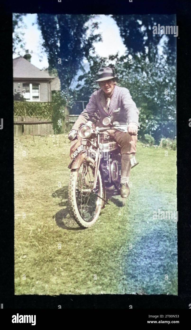 Uomo seduto a cavallo di una moto, Inghilterra, Regno Unito anni '1920 anni '1930 colorato Foto Stock