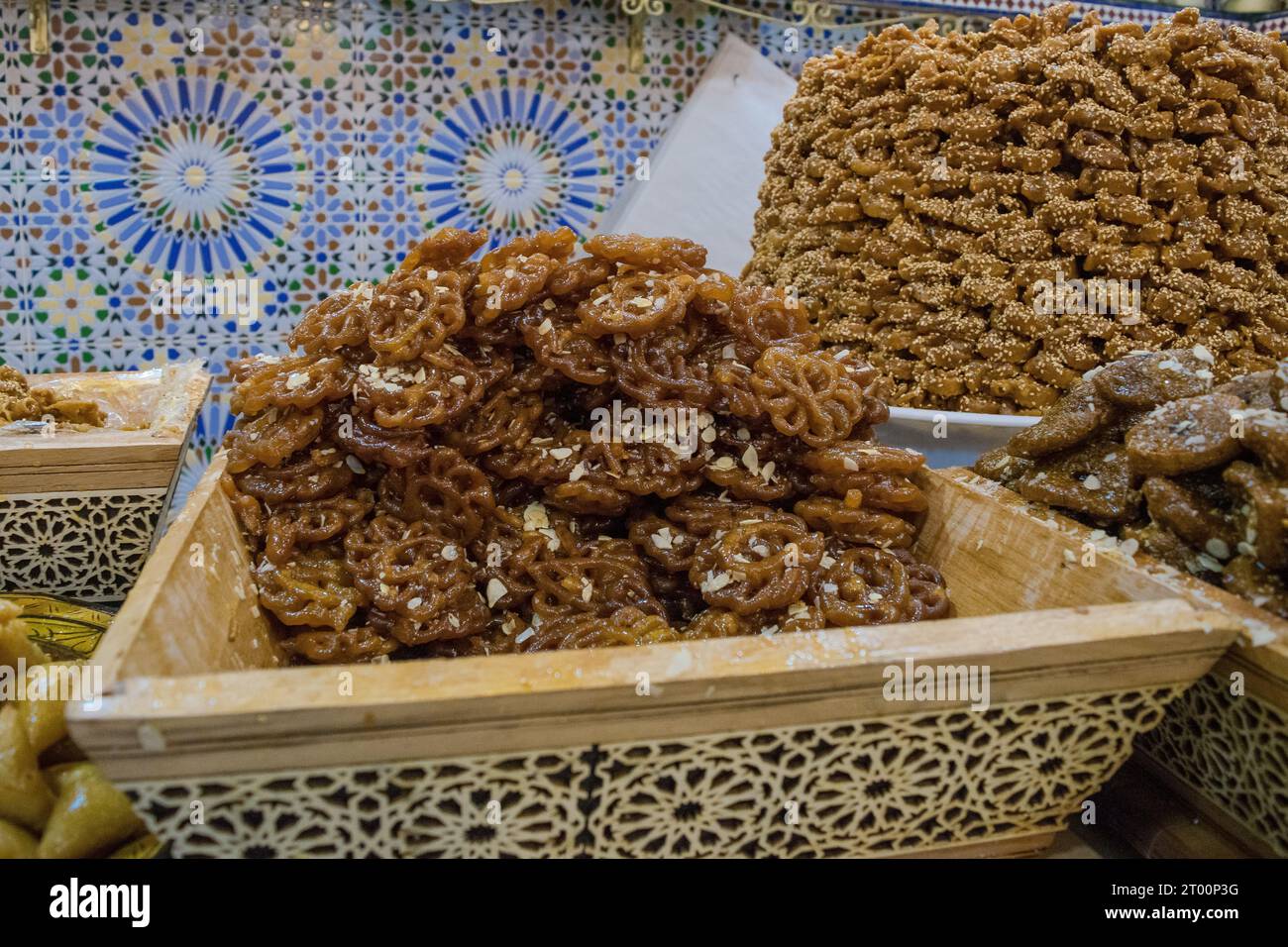 Un piatto pieno di deliziosi dolci fritti glassati al miele in mostra in una pasticceria in Marocco Foto Stock