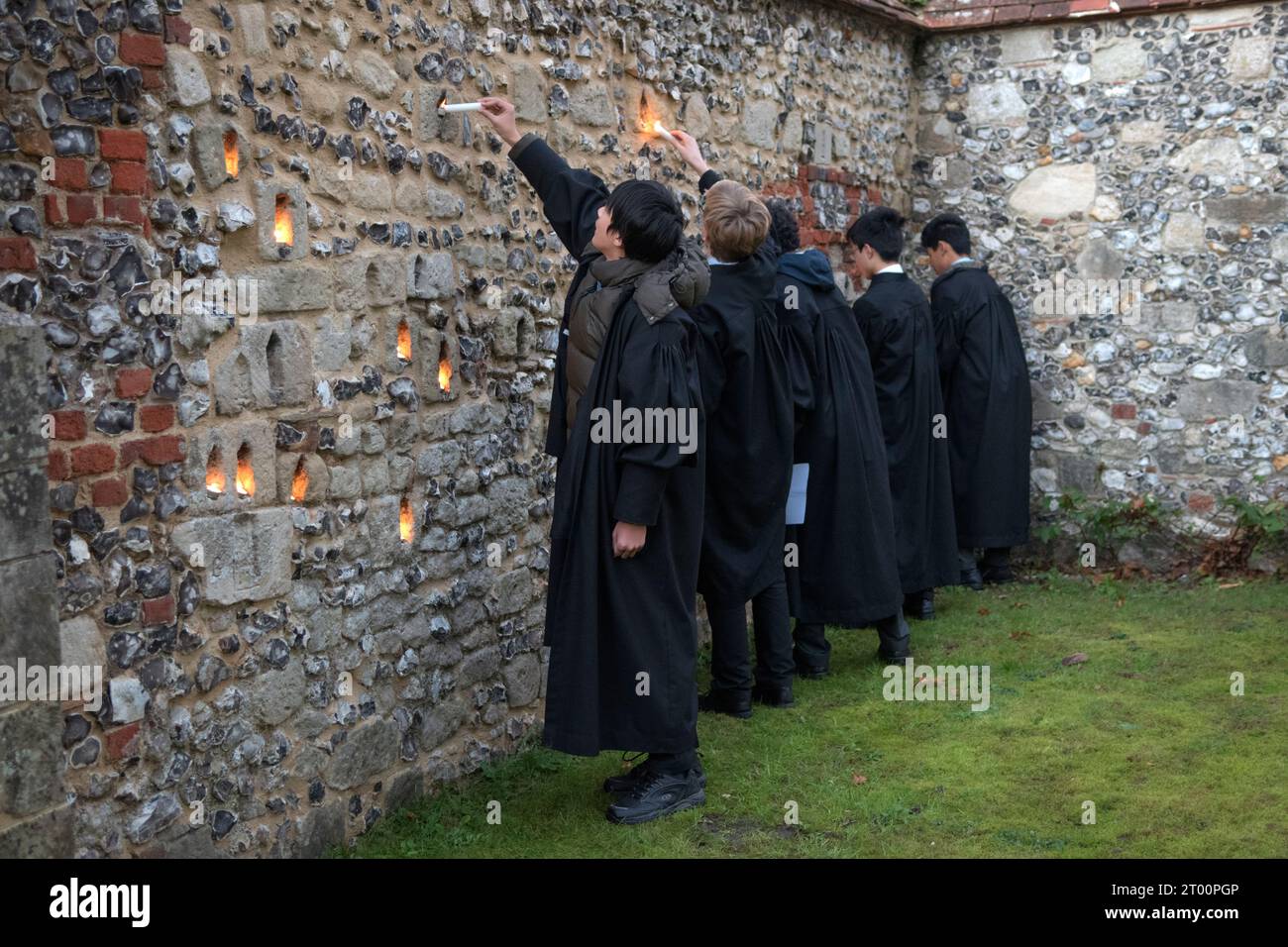 Winchester College Hampshire. Allievi alla cerimonia annuale di illumina. Private Education 2020s Regno Unito. “College Junior Men” sono studenti che sono studiosi, candele luminose collocate nelle nicchie del muro medioevale Meads. (Il muro che circonda un campo da gioco). Winchester, Hampshire, Inghilterra 9 dicembre 2022. HOMER SYKES. Foto Stock