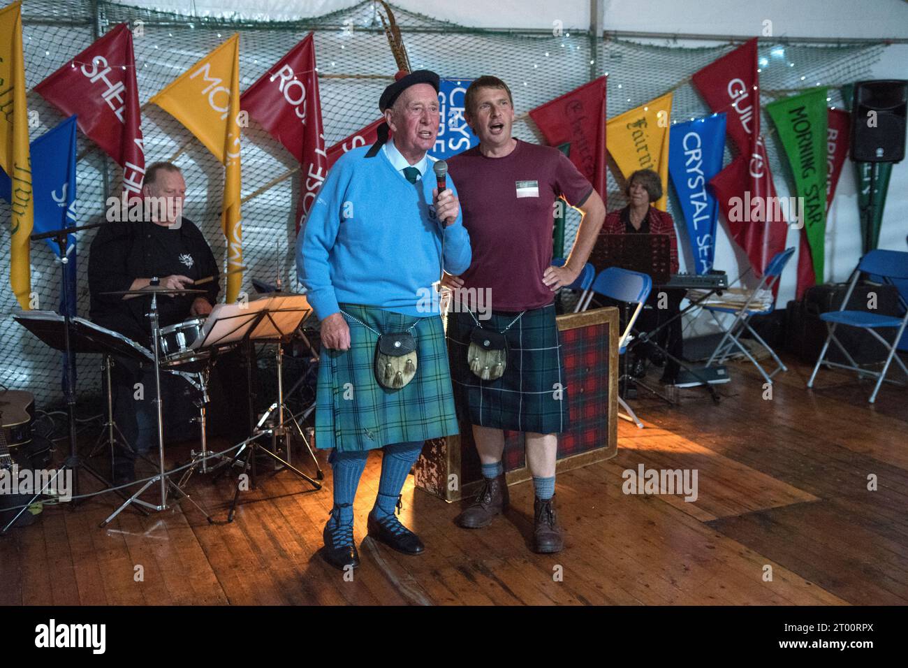 Ceilidh band Scotland. Ceilidh scozzese che canta canzoni popolari tradizionali dei pescatori. Cockenzie e Port Seton Friendly Society of Fishermen, The Box Meeting Ceilidh. L'ex pescatore e skipper Archie Johnston (86 anni) e Gareth Jones, cantando Aberlady Bay, "il Blue Forth giace davanti a noi, ragazzi, il vento soffia giusto e libero, la barca scivola sopra l'onda crestata, come se lei Hame sarebbe il ... settembre 2023 Cockenzie e Port Seton, East Lothian, Scozia. 2020 UK HOMER SYKES Foto Stock