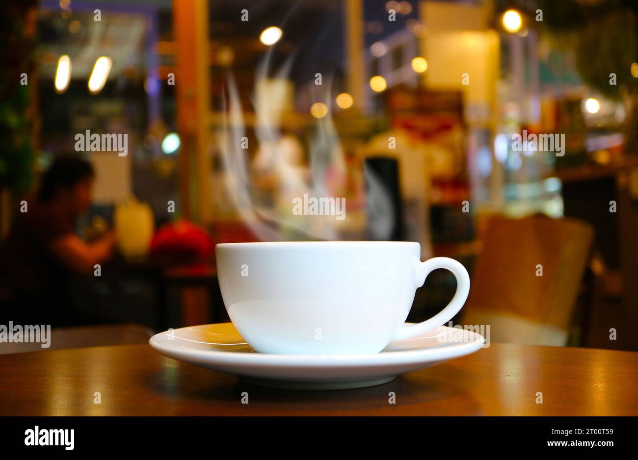 Primo piano di una tazza di caffè caldo con affumicatura su un tavolo di legno Foto Stock