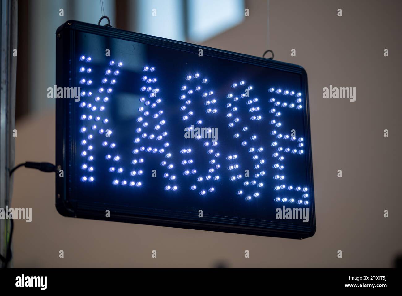 Un cartello con LED blu con scritto in tedesco "Kasse" e appeso su un registratore di cassa Foto Stock