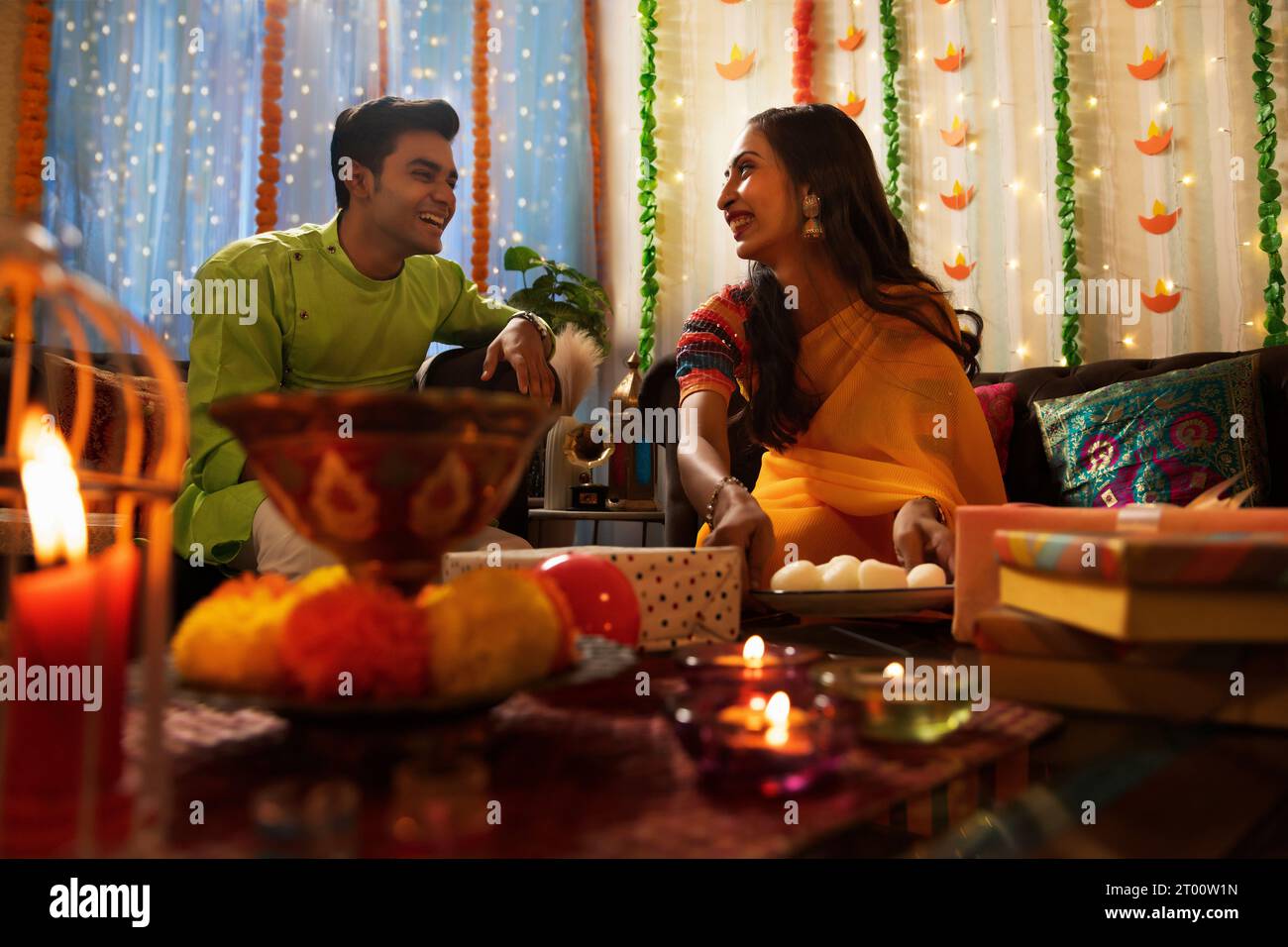 Amici che festeggiano Diwali insieme a casa Foto Stock