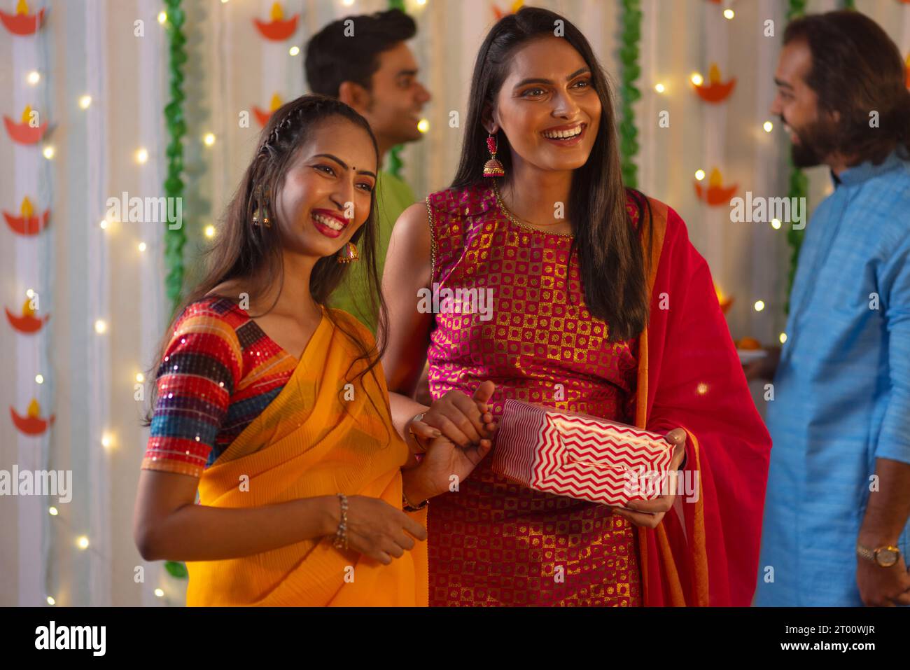 Donne sorridenti in piedi con un dono durante la celebrazione Diwali Foto Stock