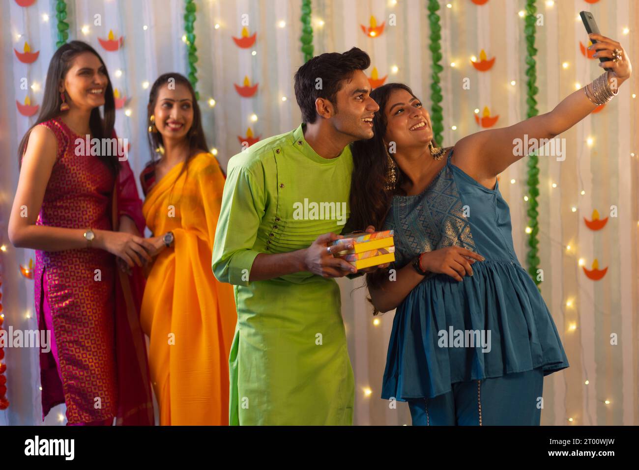 Amici che scattano selfie con il cellulare durante la celebrazione Diwali Foto Stock