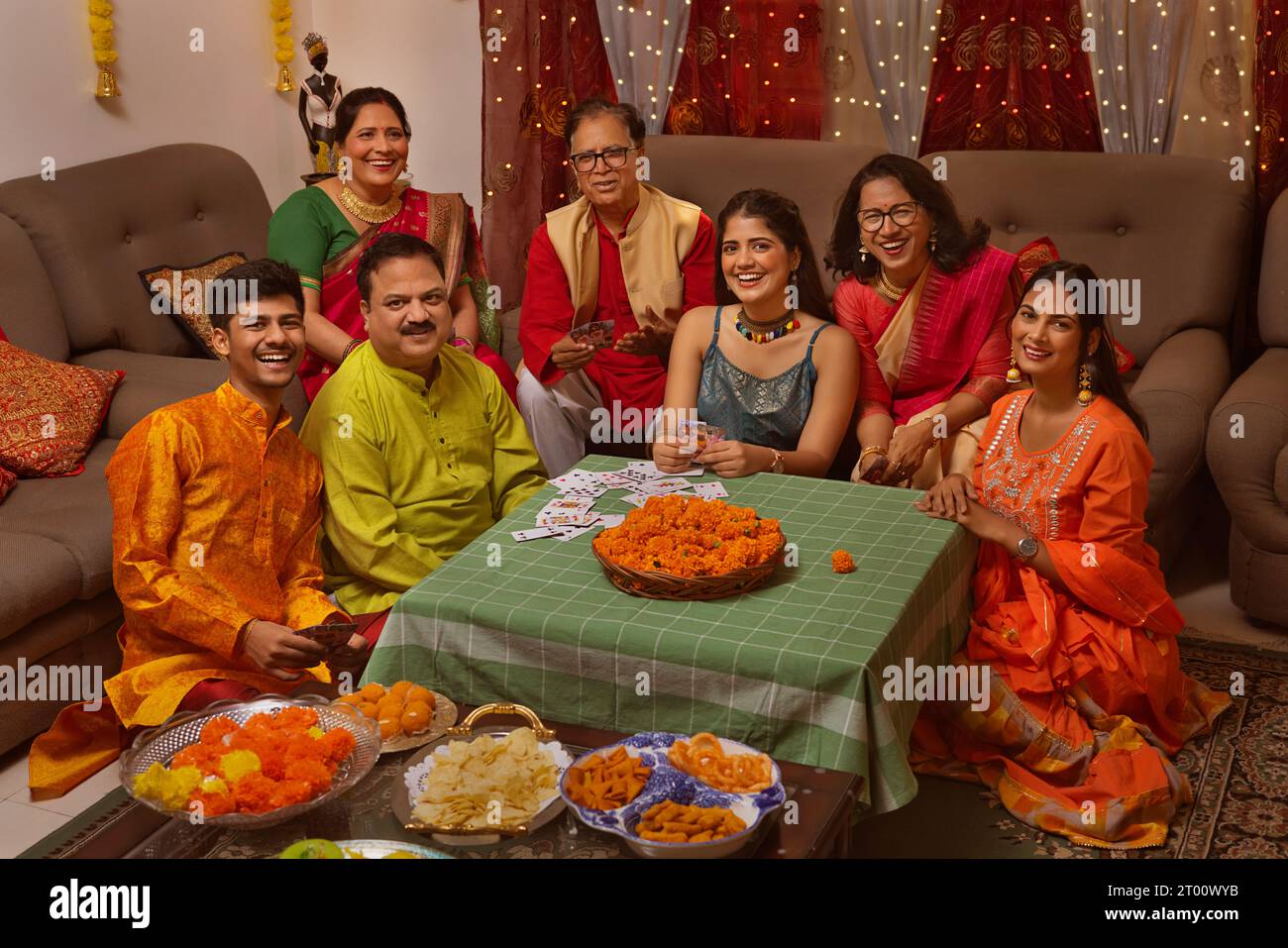 Famiglia felice in abiti tradizionali che festeggiano Diwali insieme a casa Foto Stock