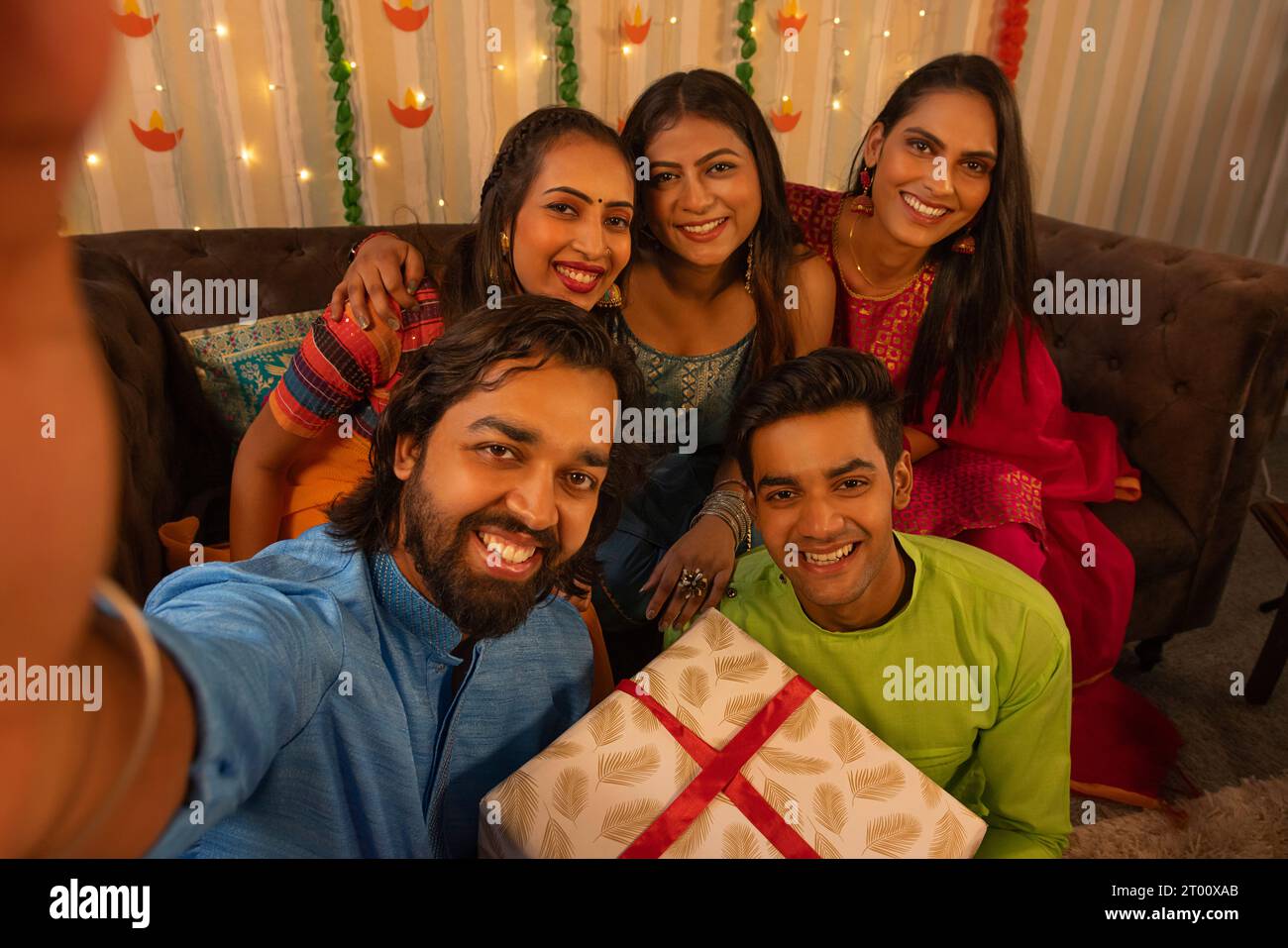 Amici che scattano selfie sul cellulare a casa durante la festa di Diwali Foto Stock