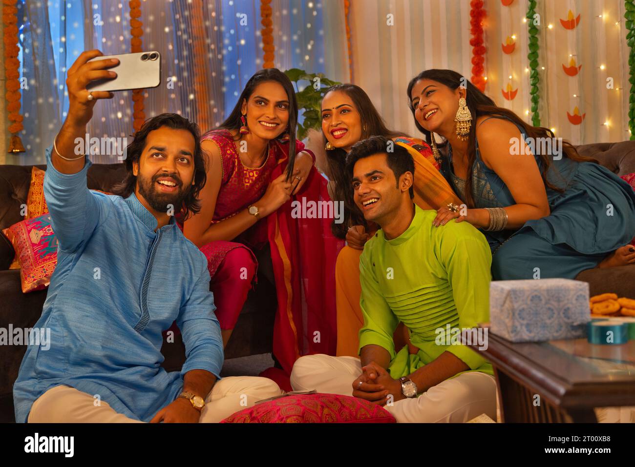 Amici che scattano selfie sul cellulare a casa durante la festa di Diwali Foto Stock