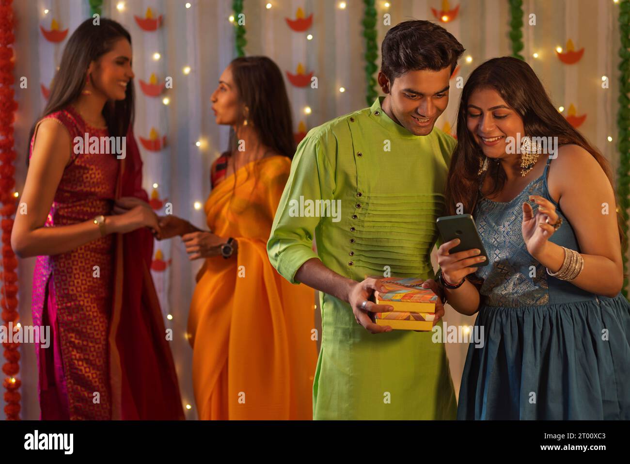 Gruppo di amici che festeggiano Diwali insieme a casa Foto Stock