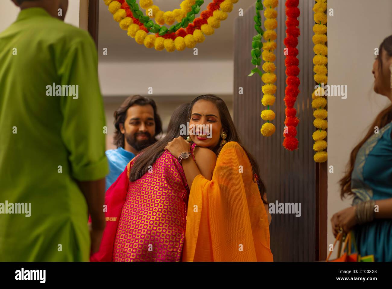 Gruppo di amici che arrivano a casa in occasione di Diwali Foto Stock