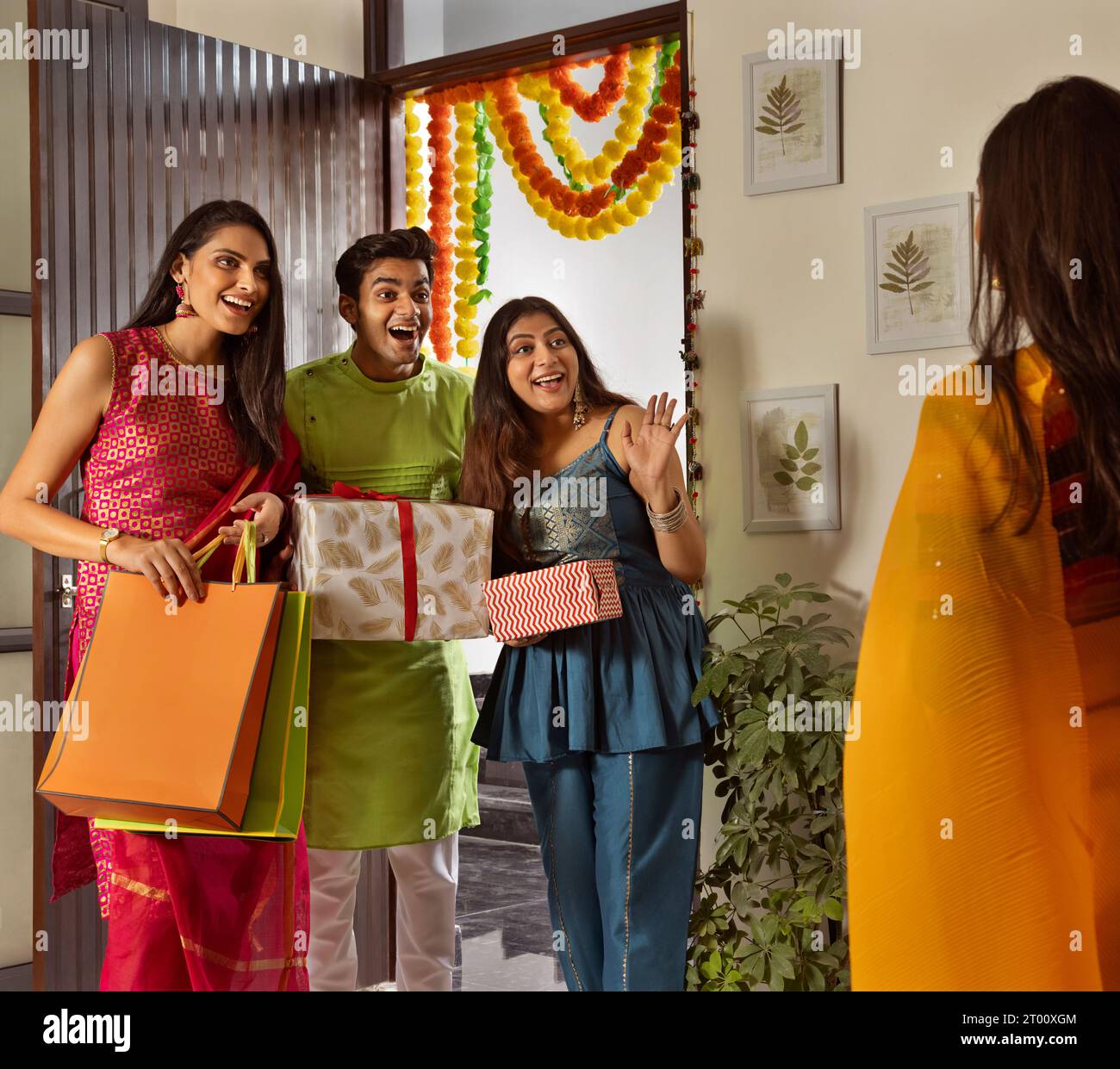 Gruppo di amici che arrivano a casa con regali in occasione di Diwali Foto Stock