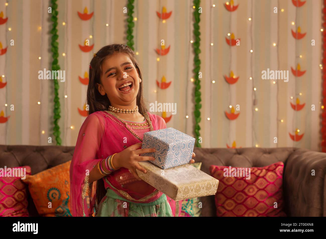 Ragazza che sorride e offre un regalo in occasione di Diwali Foto Stock