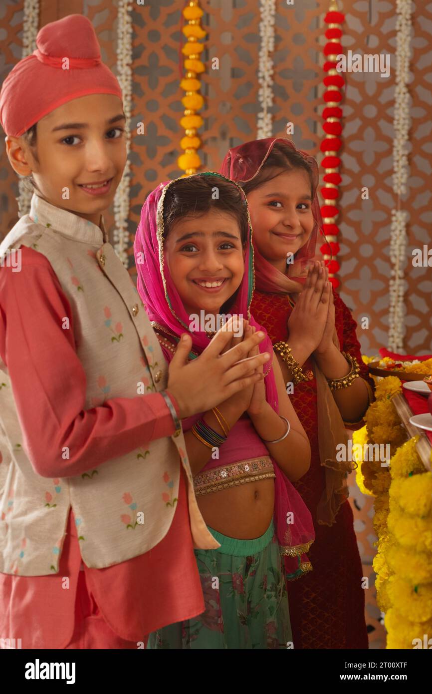 Gruppo di bambini che offrono preghiere (Dea Laxmi, dea della ricchezza) durante le celebrazioni Diwali Foto Stock