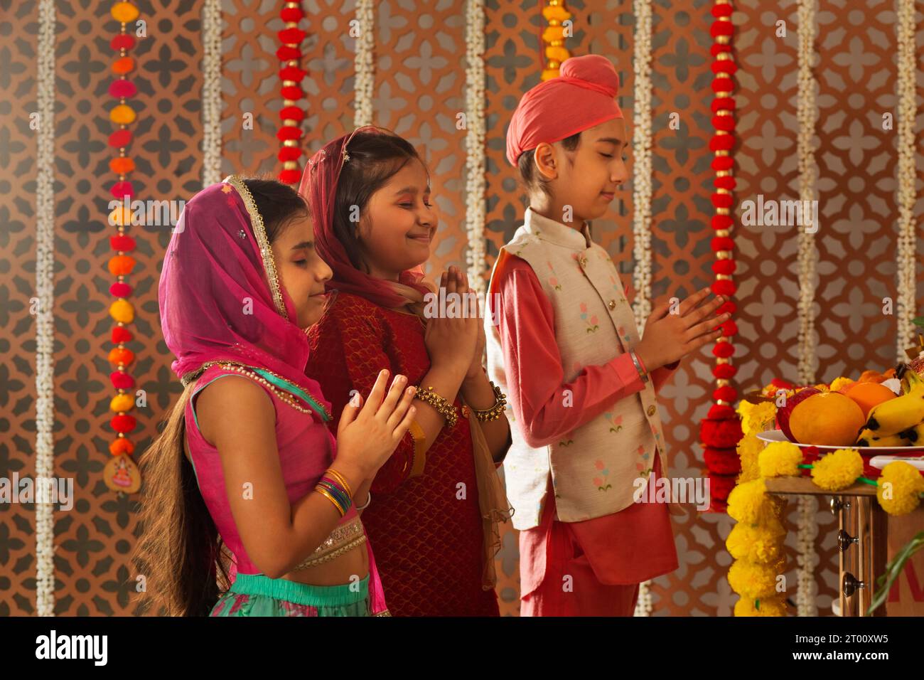Gruppo di bambini che offrono preghiere (Dea Laxmi, dea della ricchezza) durante le celebrazioni Diwali Foto Stock