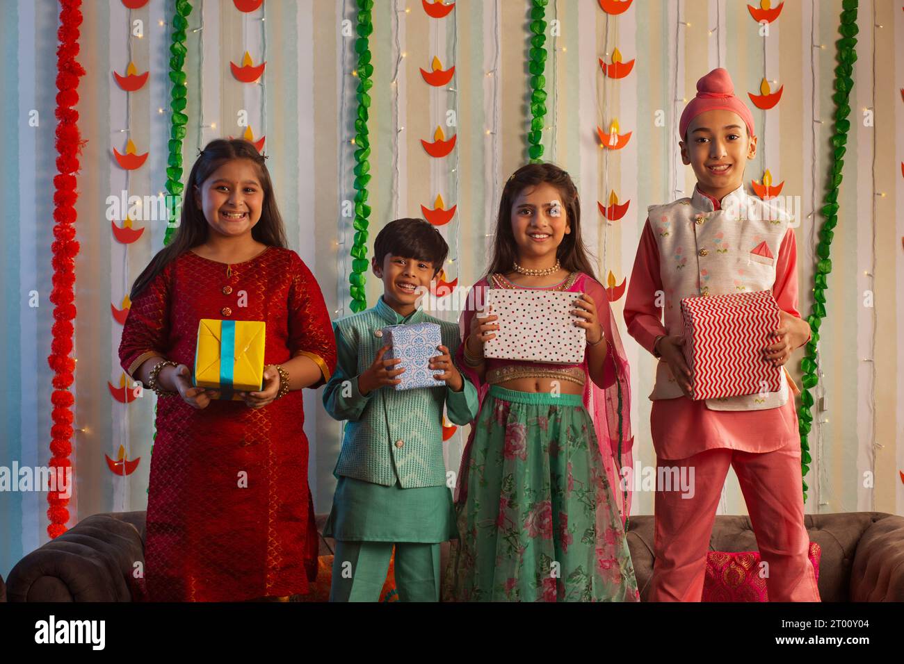 Bambini in piedi insieme ai regali Diwali a casa Foto Stock