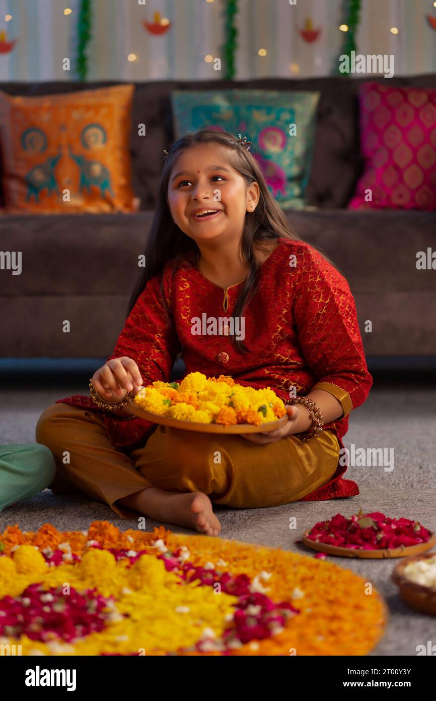 Ragazza che fa rangoli floreali in occasione di Diwali Foto Stock