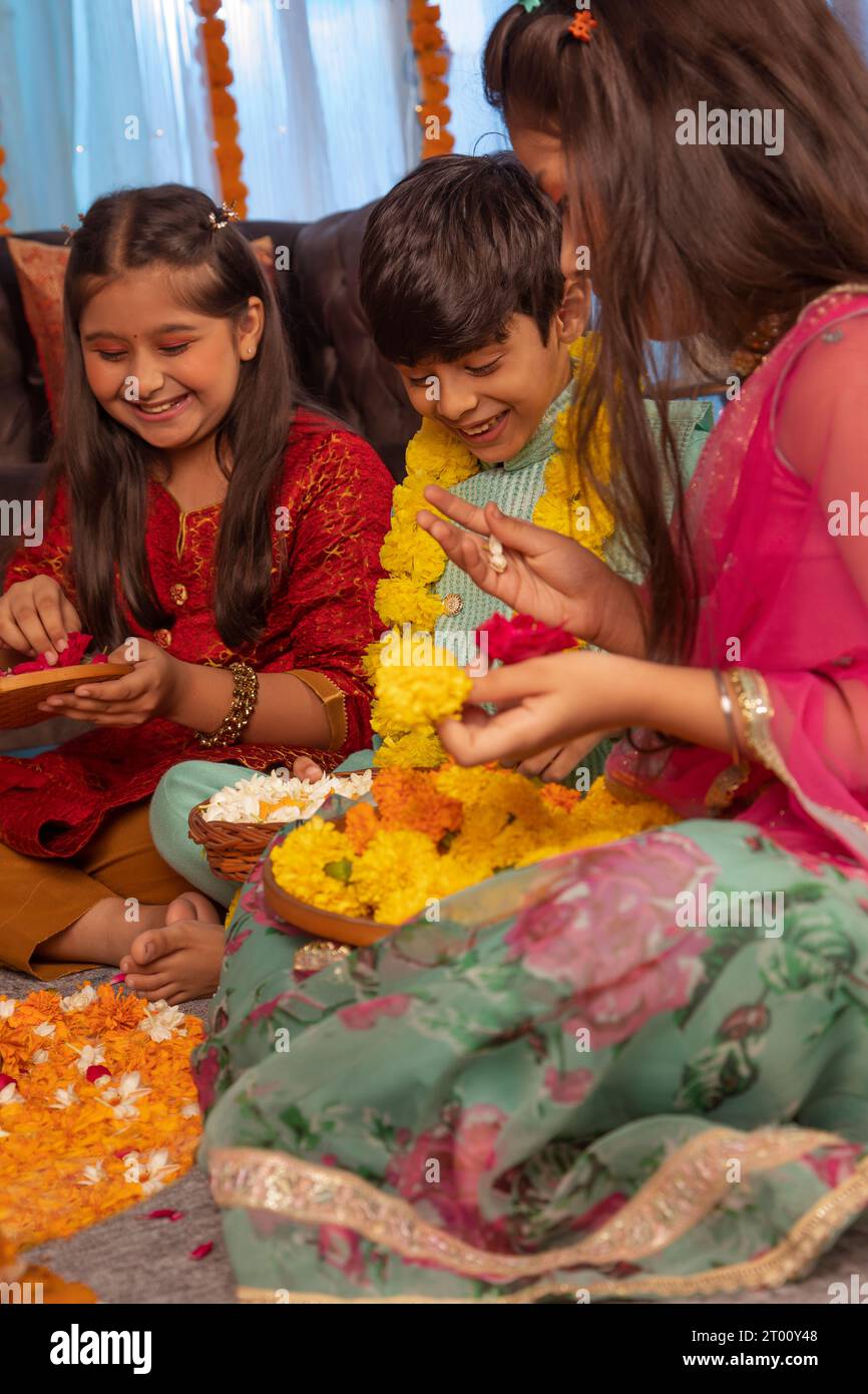 Bambini che fanno rangoli floreali insieme in occasione di Diwali Foto Stock