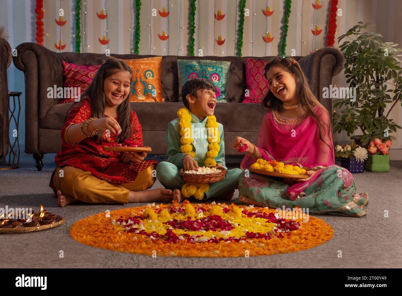 Bambini che fanno rangoli floreali insieme in occasione di Diwali Foto Stock