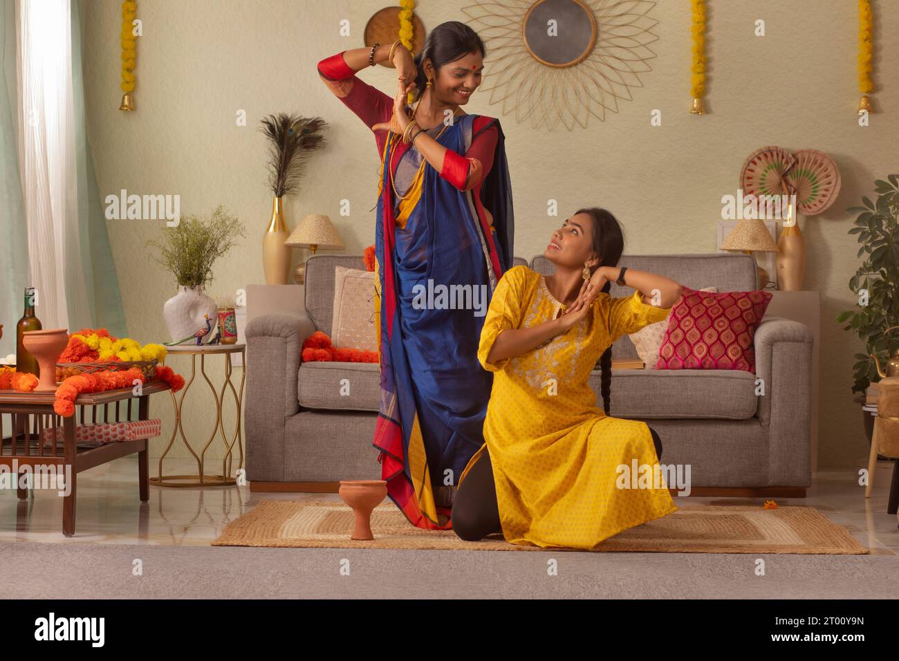 Famiglia bengalese che pratica danza a casa in occasione di Durga Puja Foto Stock