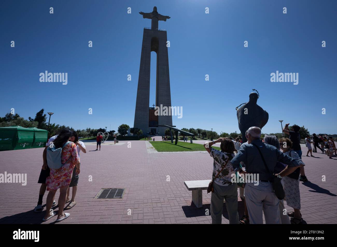 27 agosto 2023, Lisbona, Portogallo: Diversi turisti sono visti passeggiare nelle vicinanze del monumento di Cristo Re, ad Almada, Lisbona. Il Santuario Nazionale di Cristo Re è un monumento religioso situato nella città di Almada, nell'area metropolitana di Lisbona, in Portogallo. Si tratta di un portico coronato dalla statua di Gesù Cristo a braccia aperte di fronte alla città di Lisbona ed è uno degli edifici più alti del Portogallo, con 110 metri di altezza. (Immagine di credito: © Jorge Castellanos/SOPA Images via ZUMA Press Wire) SOLO USO EDITORIALE! Non per USO commerciale! Foto Stock