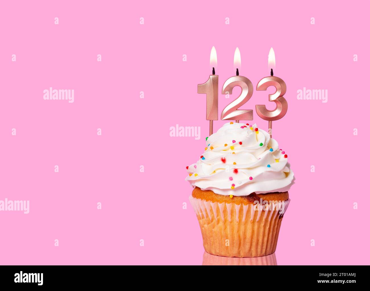 Torta di compleanno con candela numero 123 - su sfondo rosa. Foto Stock