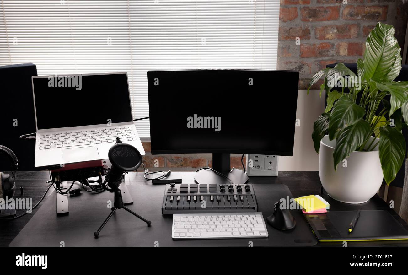 Configurazione podcasting con computer, tastiera e microfono sulla scrivania con impianto a casa Foto Stock