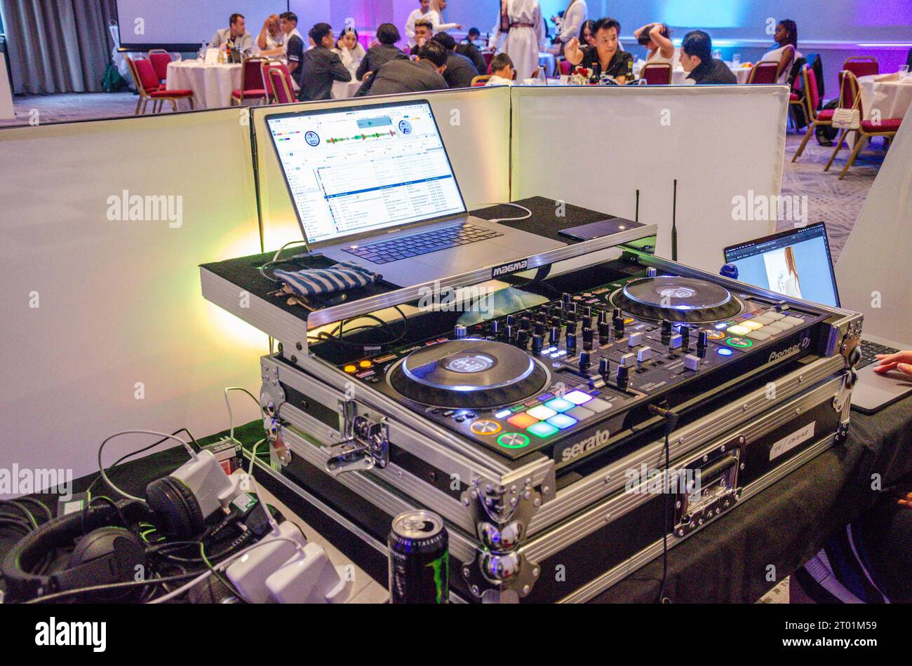 Un DJ con postazione di mixaggio e un computer portatile per ascoltare musica e divertirsi durante una festa Foto Stock