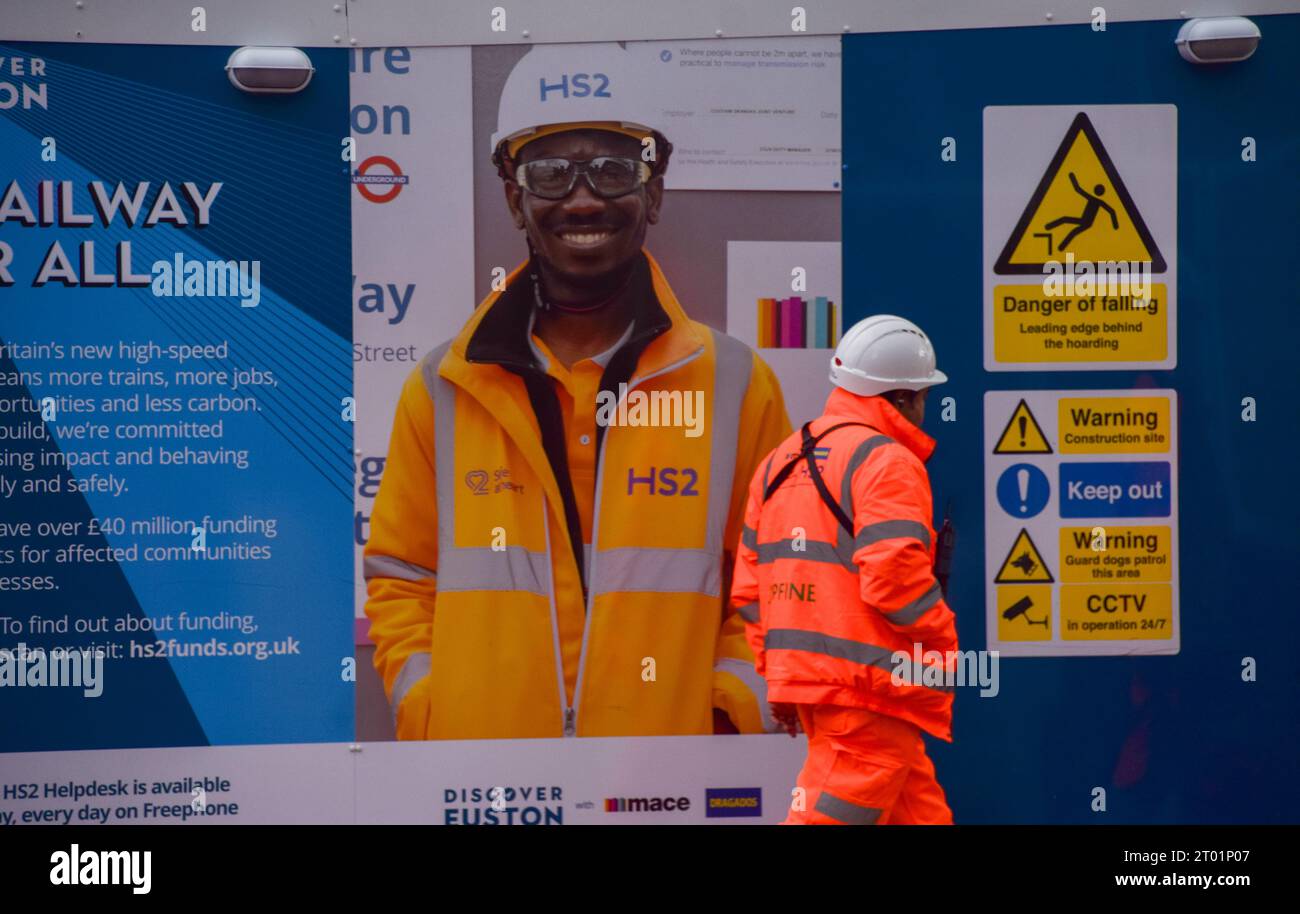 Londra, Regno Unito. 3 ottobre 2023. Un lavoratore passa davanti al cantiere HS2 alla stazione di Euston, come i rapporti suggeriscono che parte della linea ferroviaria High Speed 2, tra Birmingham e Manchester, potrebbe essere tagliata a causa dei costi vertiginosi. Il progetto multimiliardario di sterline è stato afflitto da problemi e ritardi. Credito: Vuk Valcic/Alamy Live News Foto Stock