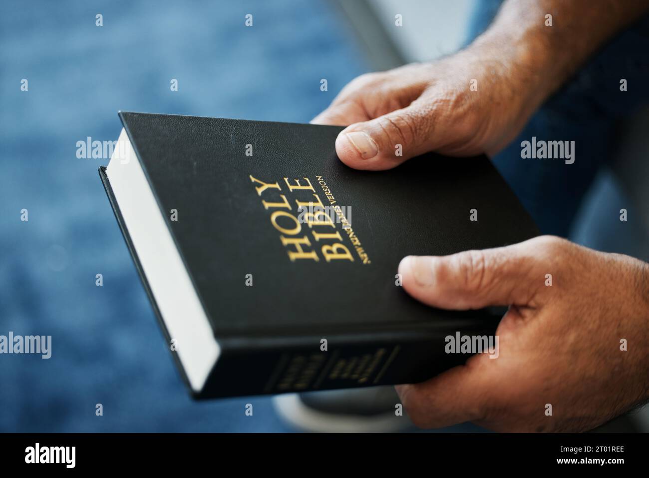 Bibbia, libro e mani dell'uomo in casa con studio della fede cristiana, della religione o della spiritualità. Santo, adorazione e persona con il Vangelo Foto Stock