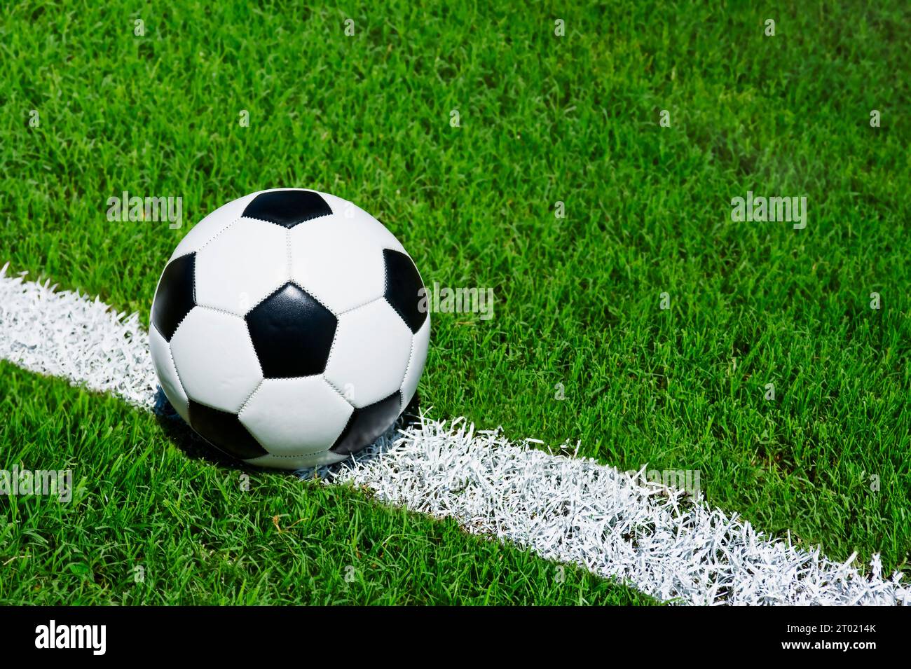 Pallone da calcio seduto sulla linea centrale di un campo da calcio Foto Stock