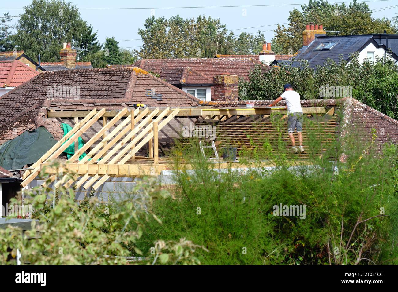 Costruttori che lavorano su un'estensione del tetto di un bungalow suburbano a Shepperton, Surrey, Inghilterra, Regno Unito Foto Stock