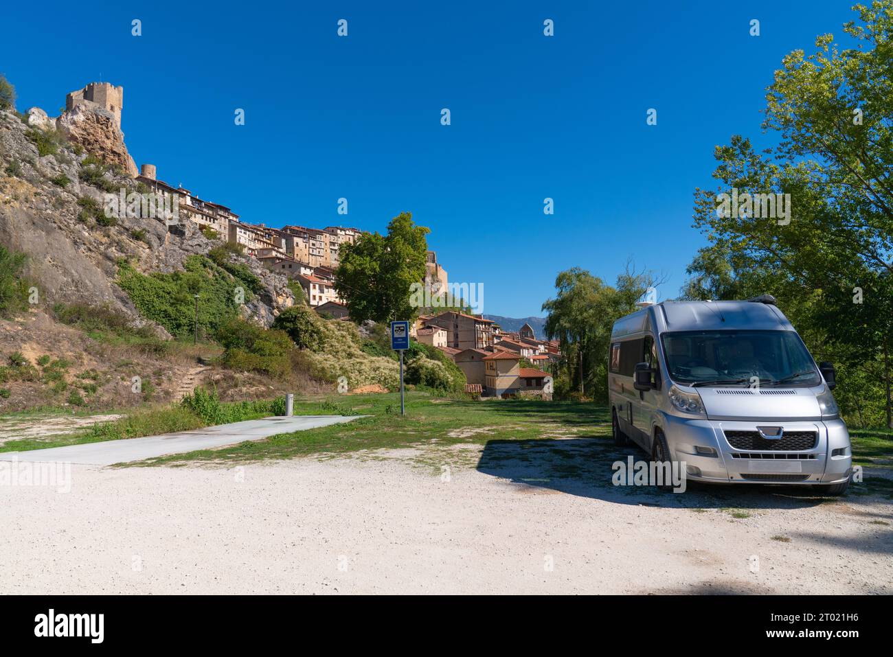 Camper parcheggiato nella splendida aire spagnola con vista sul castello in cima alla collina di Frias, la provincia di Burgos Castiglia e Leon, Spagna Foto Stock