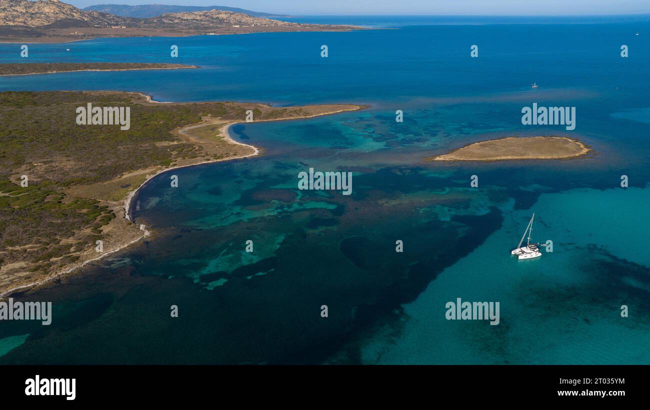 Foto aerea dell'isola di Isola piana vicino a Stintino e della spiaggia la Pelosa. Isola montuosa, acqua blu e cielo limpido. Nord-ovest p Foto Stock