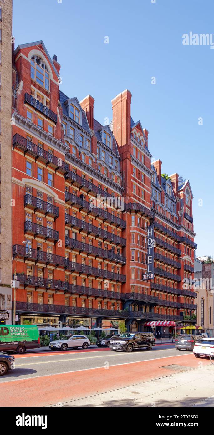 L'Hotel Chelsea domina l'isolato con la sua facciata di colore rosso scuro, prominenti balconi in ferro e un cartello illuminato a tre piani al 222 W 23rd Street in Midtown. Foto Stock