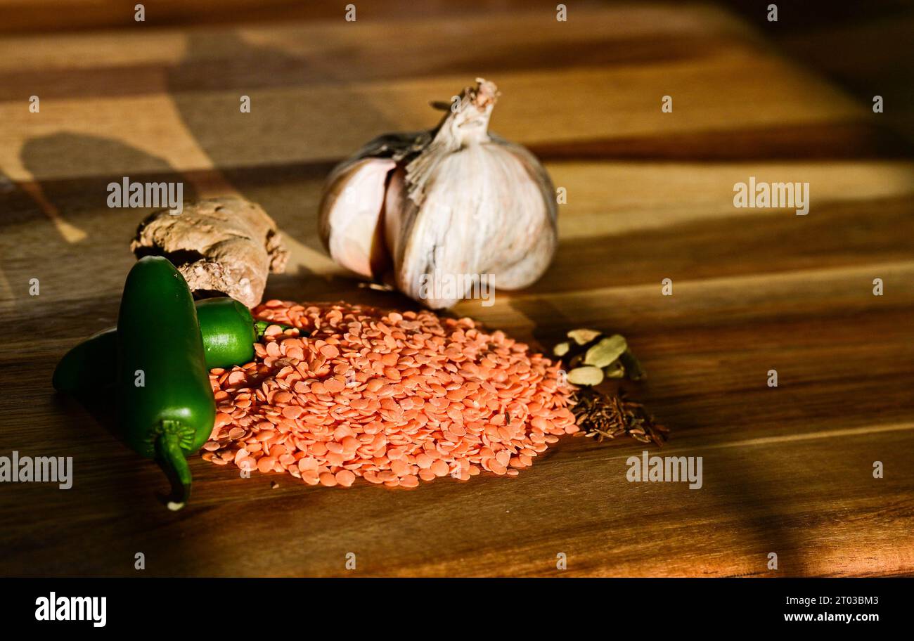 Lenticchie rosse, aglio, zenzero, peperoncini verdi e spezie utilizzate per cucinare in India o in Asia dal Credit Simon Dack Foto Stock