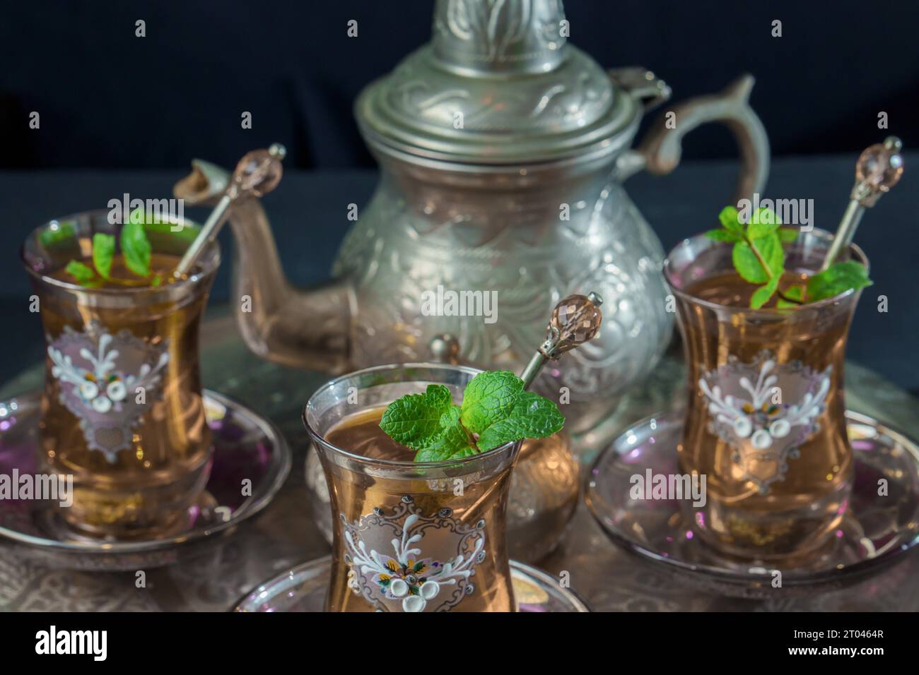 Primo piano di un tradizionale servizio di tè alla menta moresca, con bicchieri decorati e teiera argentata e ciotola di zucchero argentato Foto Stock