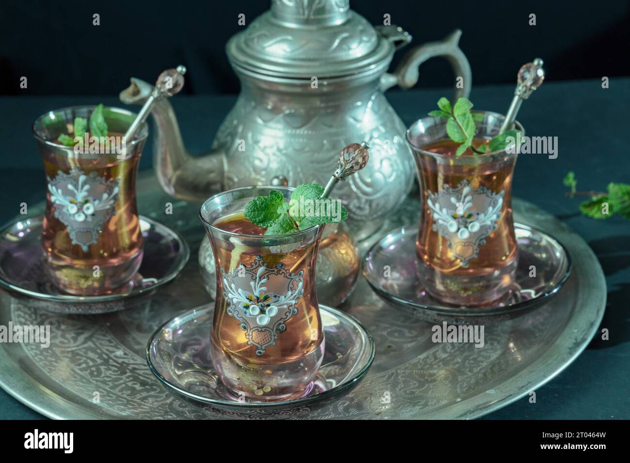 Primo piano di un tradizionale servizio di tè alla menta moresca, con bicchieri decorati e teiera argentata e ciotola di zucchero argentato Foto Stock