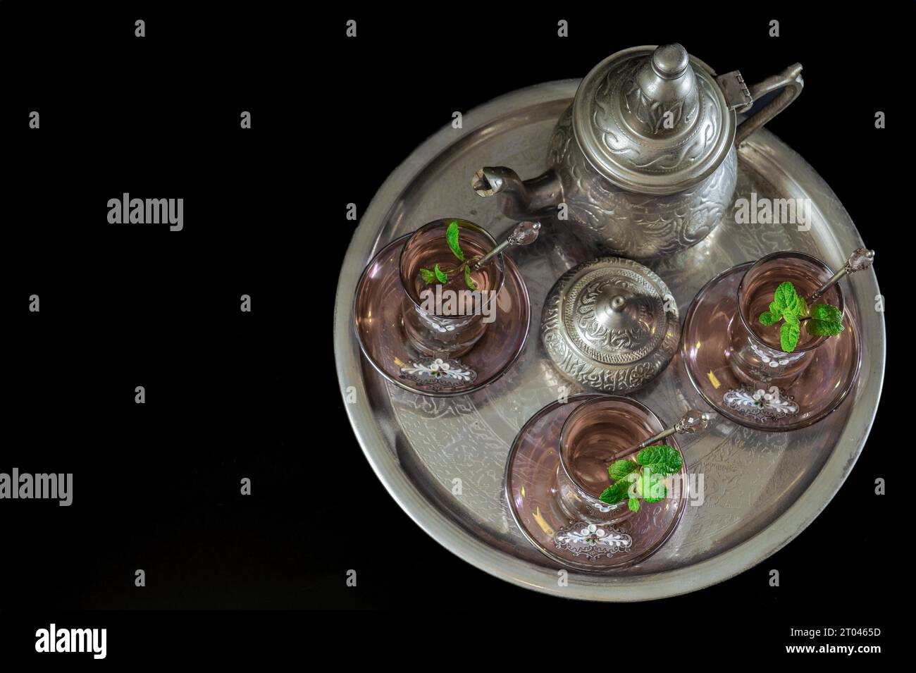 Vista dall'alto di un tradizionale servizio di tè alla menta moresca su un vassoio con bicchieri decorati, teiera argentata e ciotola da zucchero Foto Stock