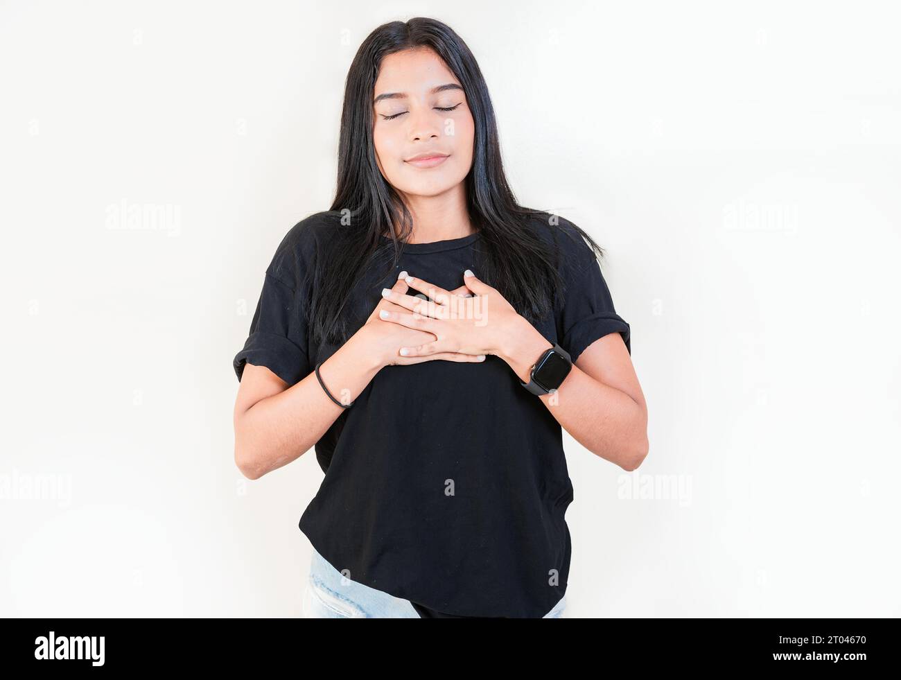 Persone grate con le mani sul petto. Ragazza adolescente grata che sorride con le mani sul petto isolato. Ragazza latina positiva con le mani sul petto Foto Stock