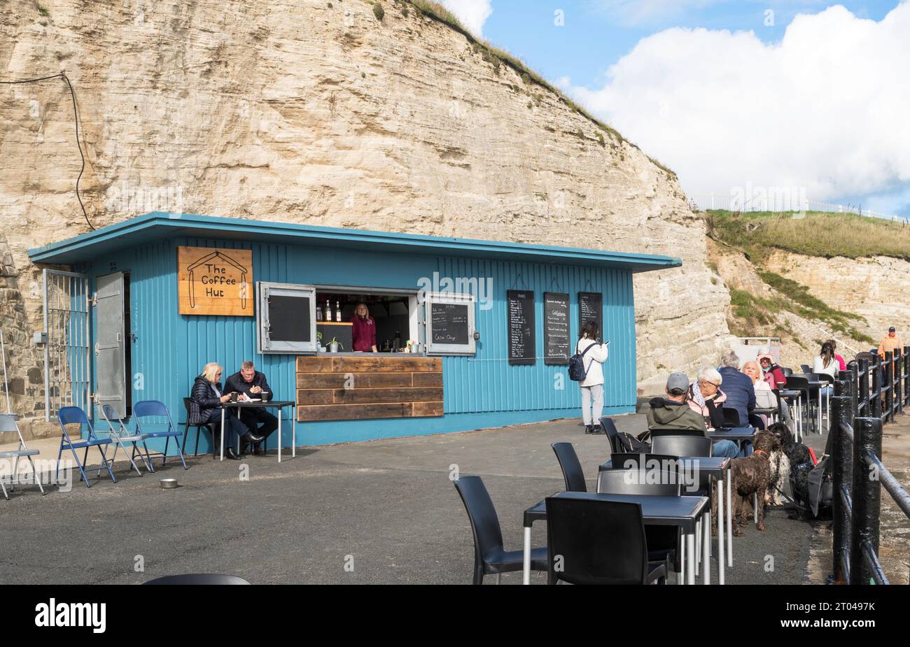 La gente sedeva fuori dal Coffee Hut sul lungomare di Roker, Sunderland, Inghilterra, Regno Unito Foto Stock